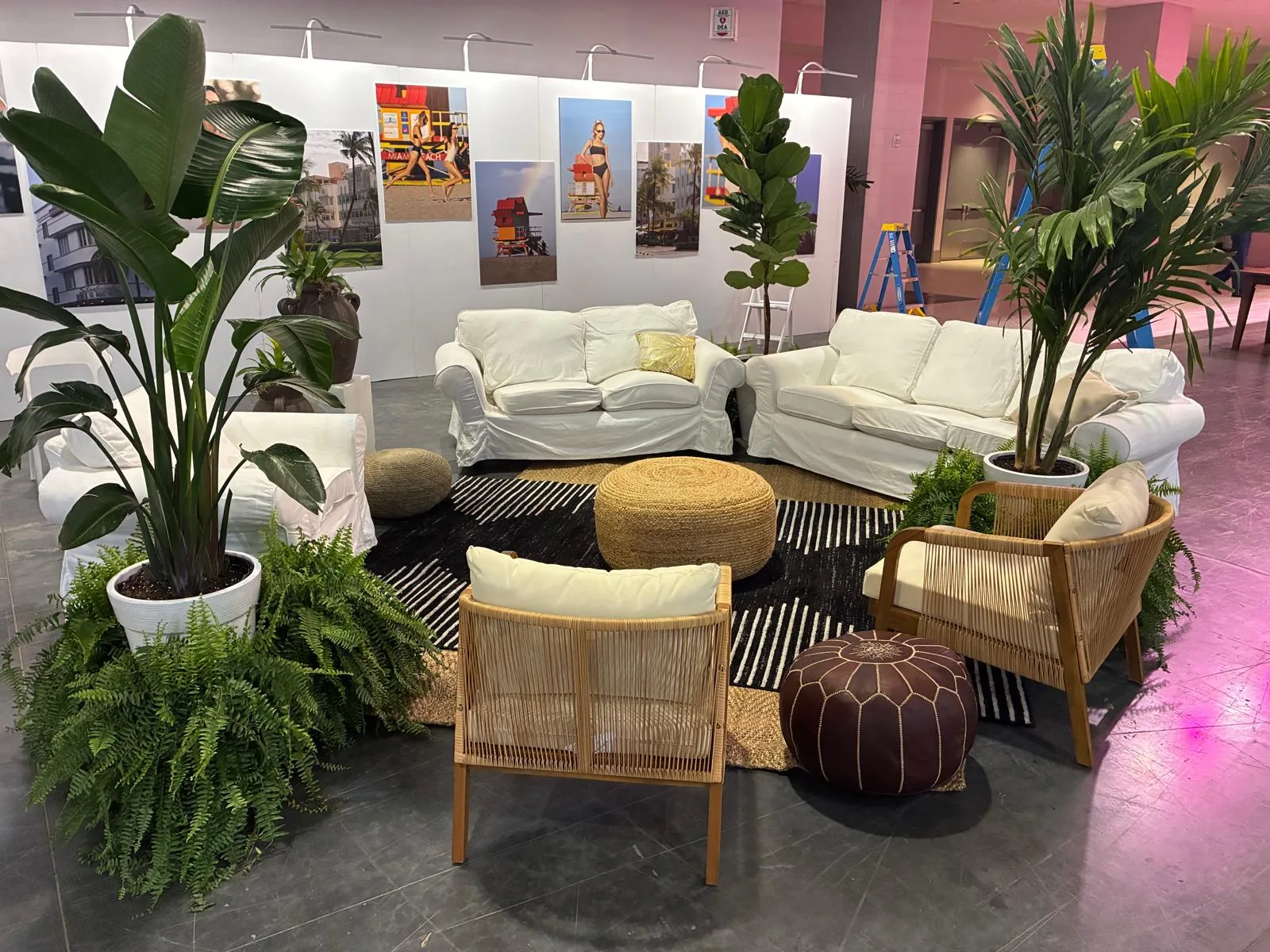 Bird-of-paradise and palms staging a white-sofa event lounge